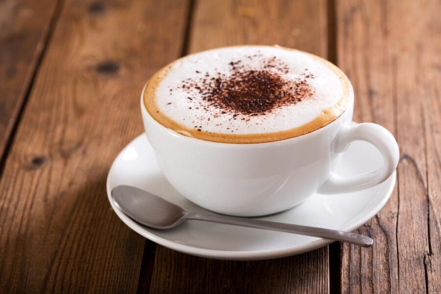 Cup of cappuccino coffee with micro foam on wooden table