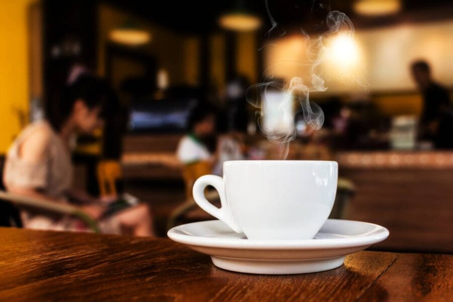 A steaming cup of coffee in a coffee shop