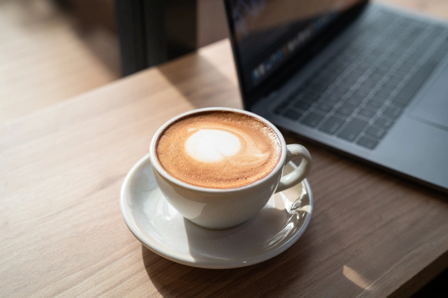 Cup of coffee beside a laptop computer